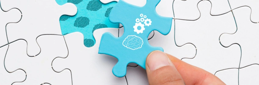 uma-mesa-de-quebra-cabeca-branco-com-duas-pecas-azul-com-um-cerebro-desenhado-em-uma-das-pecas