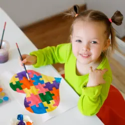 criança-brincando-com-tinta-e-pintando-um-coração-com-várias-cores-que-representam-o-autismo